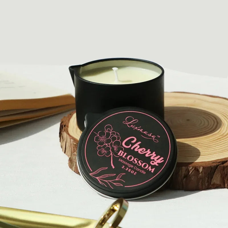 Black cherry blossom massage candle with lid on a wooden surface