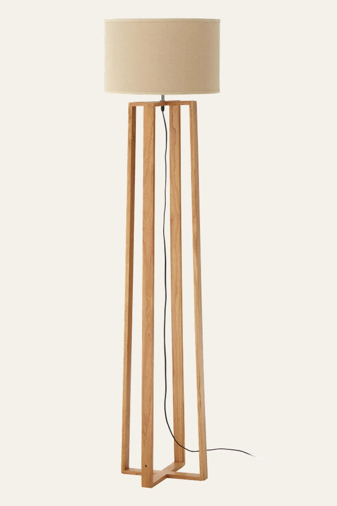 Aelia Wooden Floor Lamp with tall natural oak open-frame base, beige drum fabric shade and exposed black power cord.