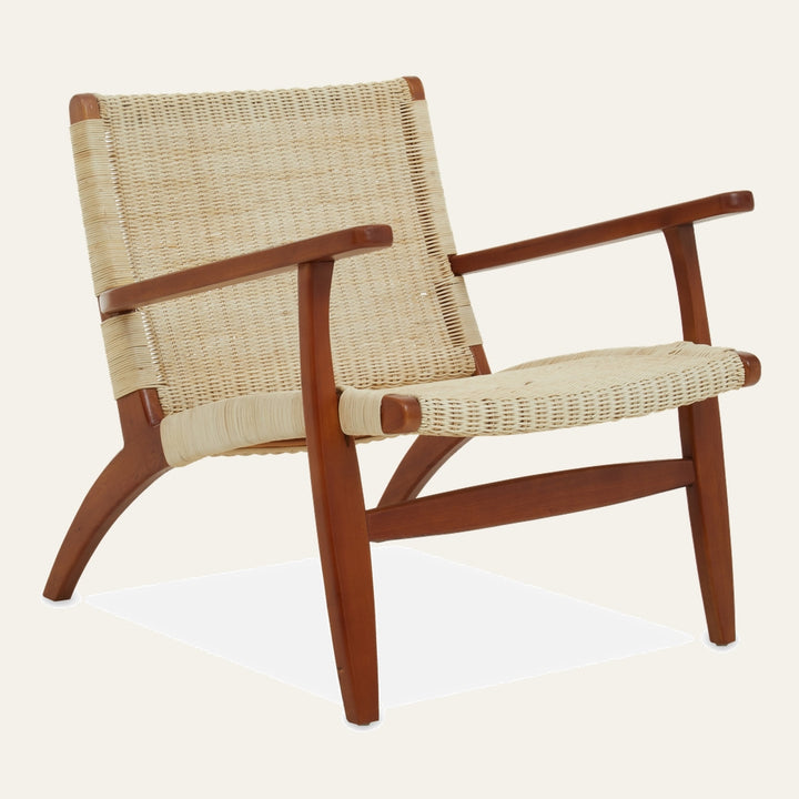 Amavaya Woven Rattan Chair with woven natural rattan seat and back on a warm brown wooden frame with armrests and slanted lounge profile