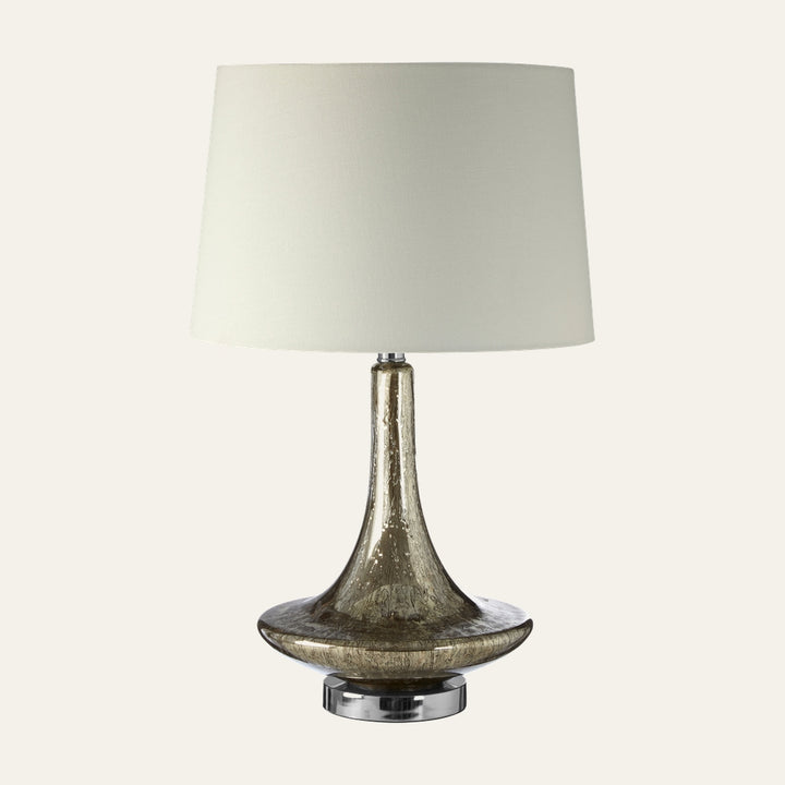 Amayana Glass Table Lamp with amber-brown bubbled glass flared base, chrome circular pedestal, and white tapered fabric drum shade