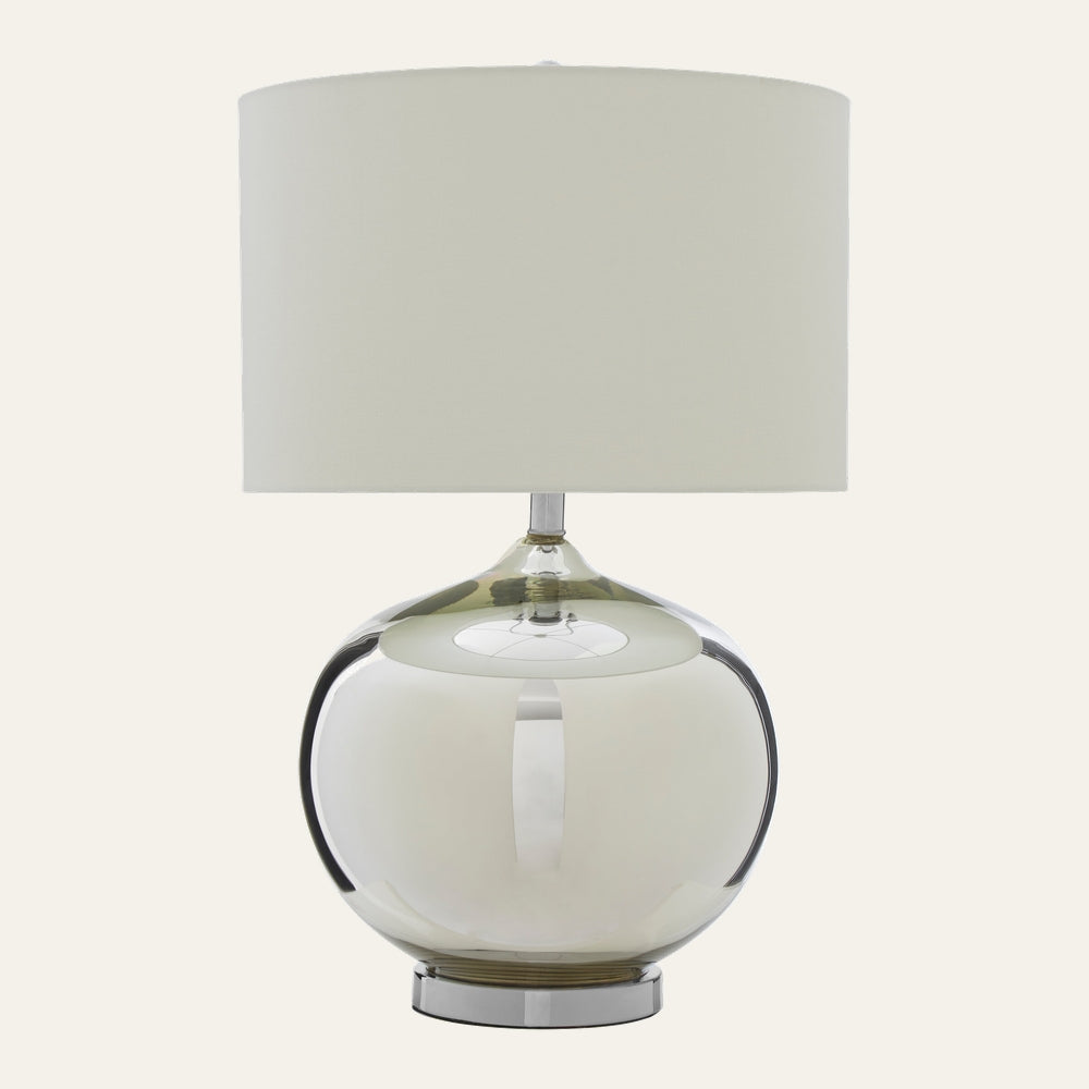 Amora Glass Table Lamp with large round smoky glass base, chrome pedestal foot and cream fabric drum shade