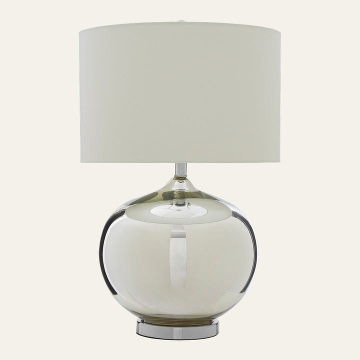 Amora Glass Table Lamp with large round smoky glass base, chrome pedestal foot and cream fabric drum shade
