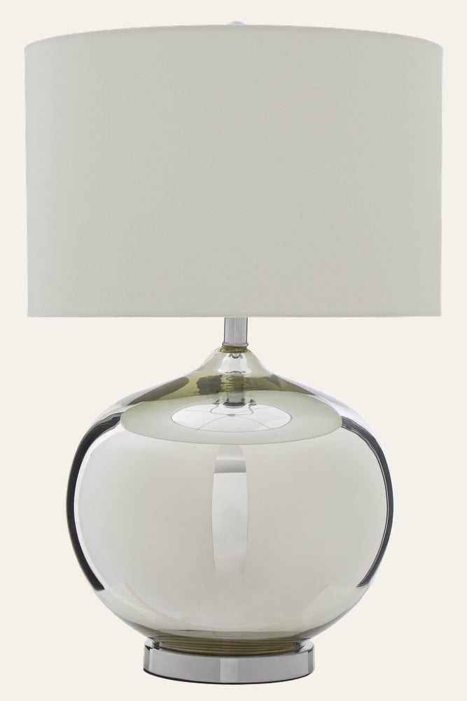 Amora Glass Table Lamp with round reflective glass base (subtle smoke tint), chrome metal pedestal and ivory drum fabric shade