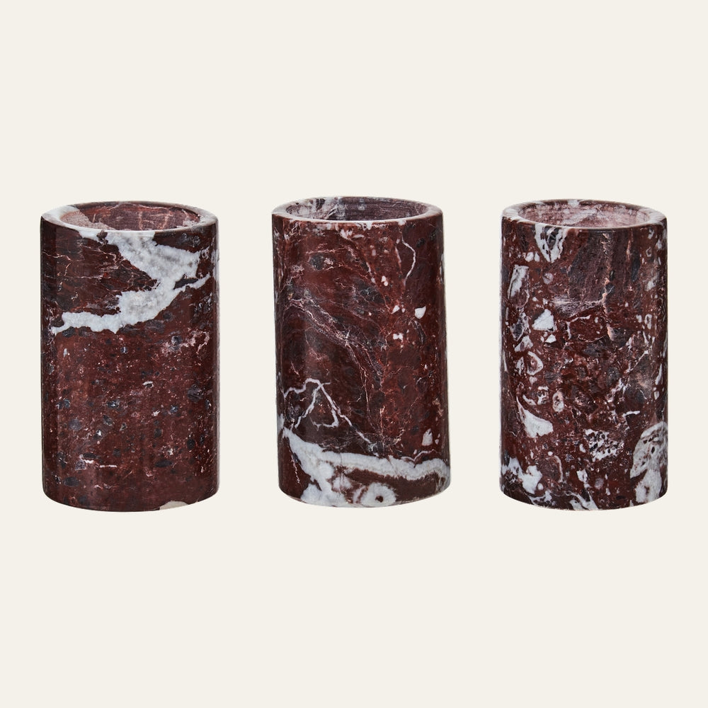 Anoria Tealight Holder Set — three cylindrical red marble tealight holders with white veining and a polished finish, arranged side by side on a neutral background