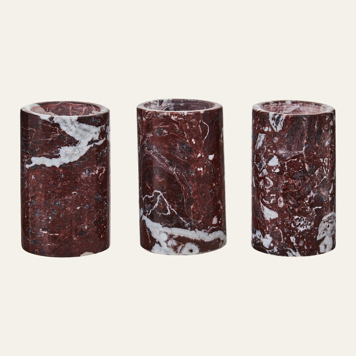 Anoria Tealight Holder Set — three cylindrical red marble tealight holders with white veining and a polished finish, arranged side by side on a neutral background