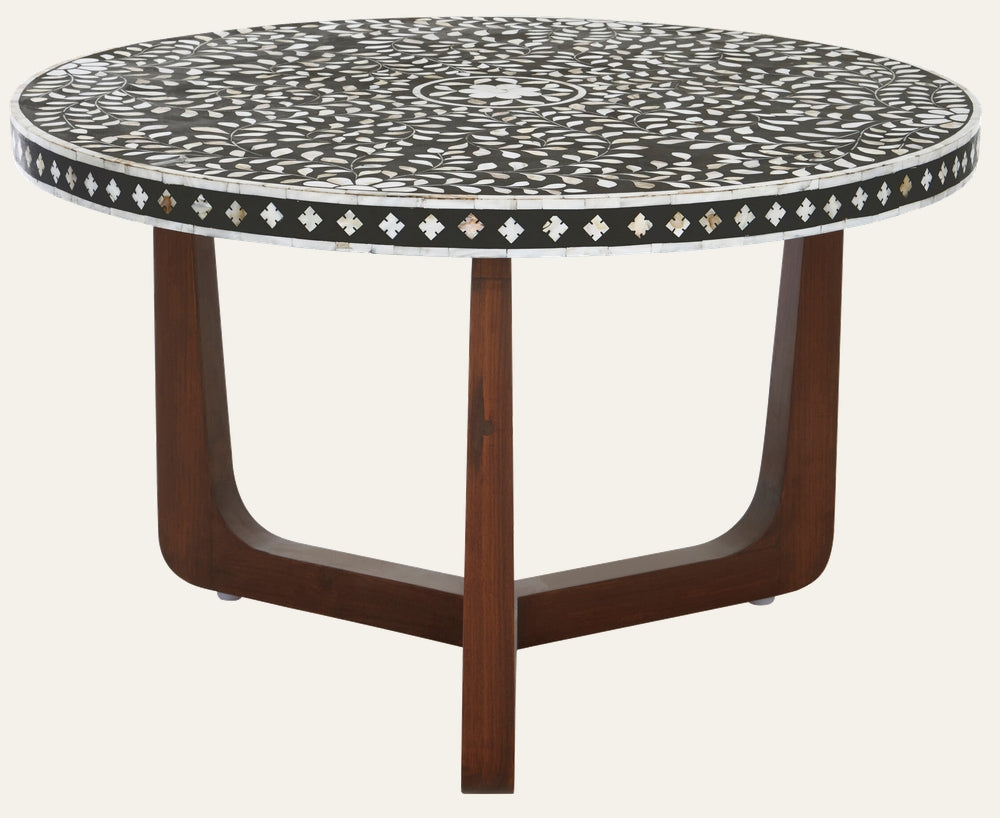 Aranelle Pearl Round Coffee Table with round black tabletop featuring white leaf mosaic inlay and diamond-pattern border, supported by curved dark wood three-leg base