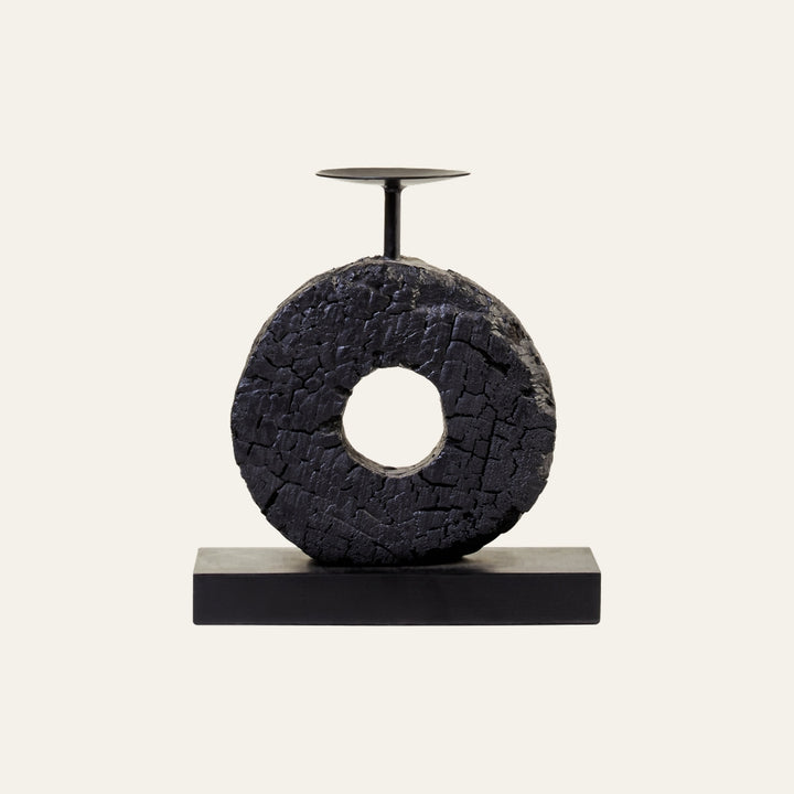 Arden Wood Log Candle Holder with circular charred wood log featuring a center hole, set on a rectangular black base and topped with a small black metal candle plate.