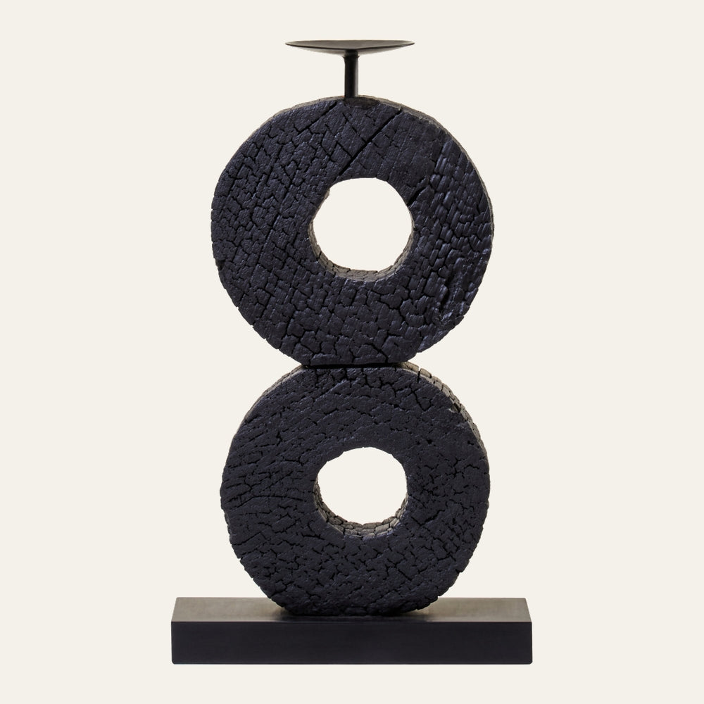 Arden Wood Log Candle Holder with two stacked charred wood donut rings, crackled black finish, metal candle plate and rod on a rectangular black base.