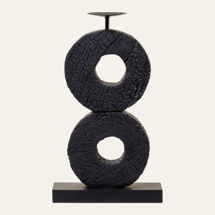 Arden Wood Log Candle Holder with two stacked charred wood donut rings, crackled black finish, metal candle plate and rod on a rectangular black base.