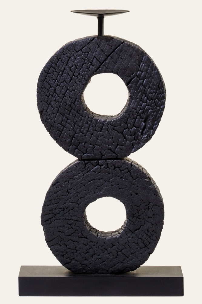 Arden Wood Log Candle Holder — two stacked charred wood log rings with center holes and cracked black finish, set on a rectangular black metal base with a small round candle plate on top.