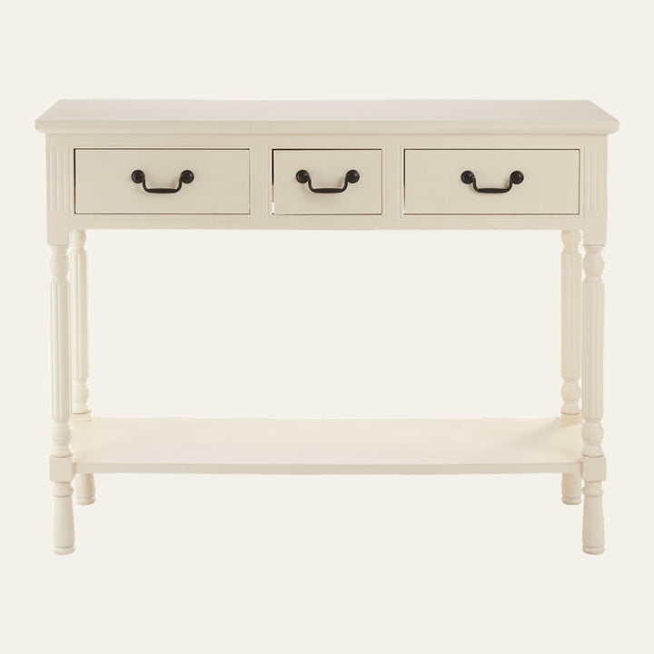 Arlen Ivory Wood Console Table with three drawers, black metal drop handles, turned legs and lower shelf in ivory painted wood finish.