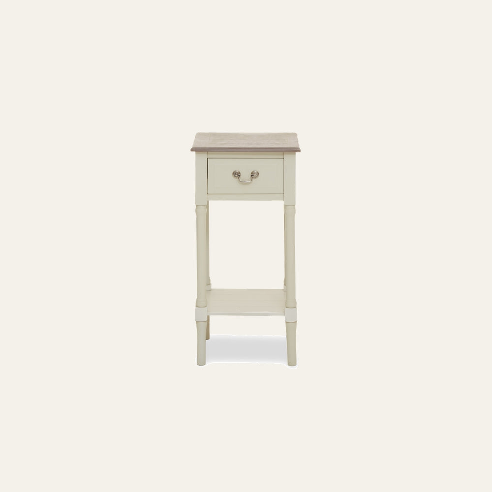 Arlen Ivory Wood Side Table — slim single-drawer side table with turned legs and lower shelf, ivory painted wood body, contrasting natural wood top and metal bail drawer pull