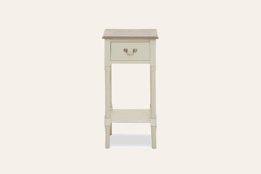 Arlen Ivory Wood Side Table — slim ivory-painted wood side table with contrasting light brown wood top, single front drawer with metal bail pull, turned legs and lower shelf