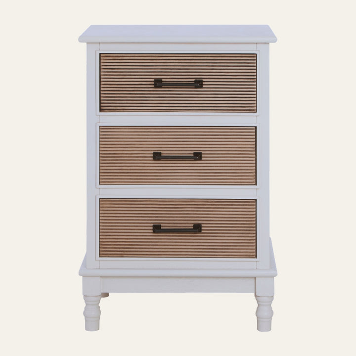 Arlen White Wood Chest of Drawers with three ribbed natural wood drawer fronts, white painted frame, dark metal bar handles and turned legs