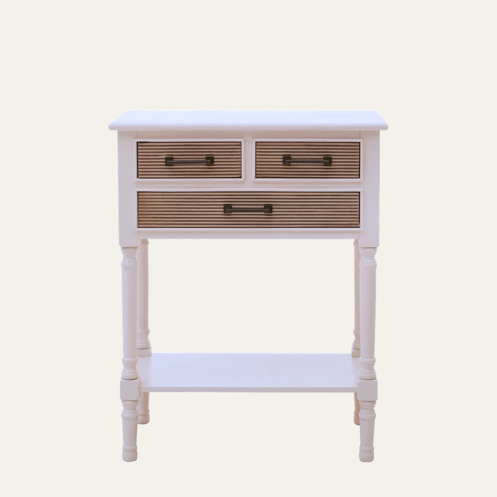 Arlen White Wood Console Table — white painted wood console with turned legs and lower shelf, three drawers with natural ribbed wood fronts and black metal handles.
