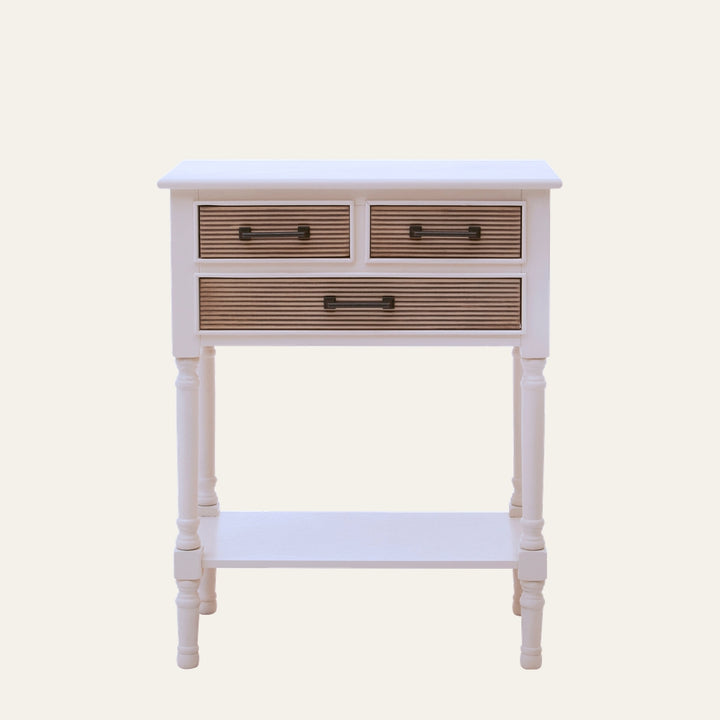 Arlen White Wood Console Table — white painted wood console with turned legs and lower shelf, three drawers with natural ribbed wood fronts and black metal handles.