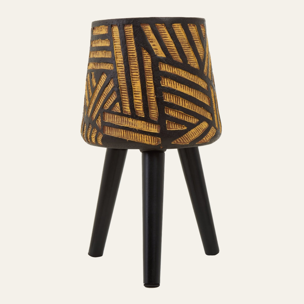 Arric Angular Leg Planter — textured dark pot with carved yellow‑gold geometric pattern mounted on three matte black angled legs.