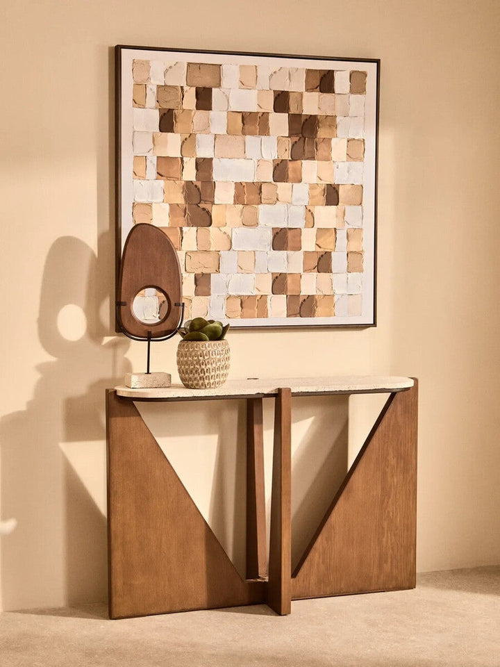 Arsen Wood Vertical Sculpture — oval vertical carved wood piece with round center cutout, medium brown wood grain finish on a slender black metal stand with a light rectangular base, displayed on a console table