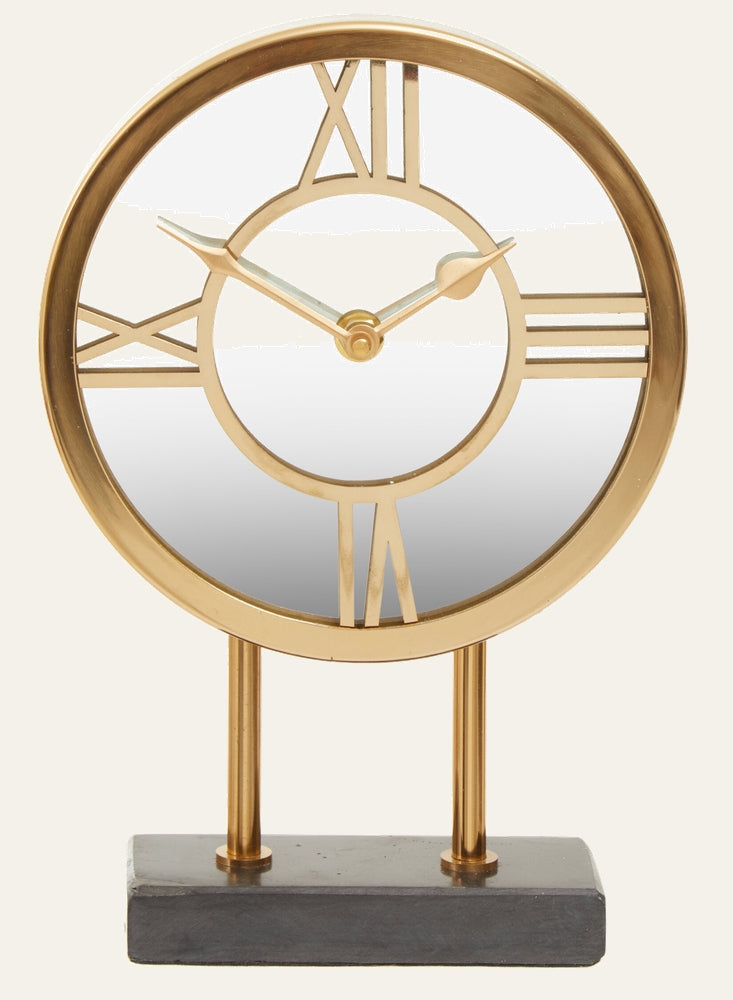 Artor Marble Clock — round gold metal open-frame clock with Roman numerals and gold hands, mirrored center, supported by twin gold rods on a dark marble rectangular base.