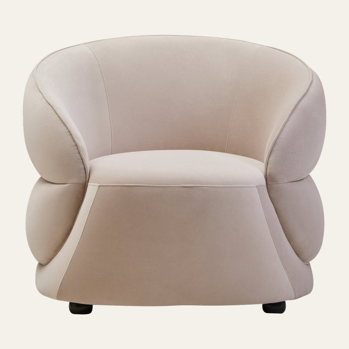 Avaya Stone Velvet Curved Chair in stone velvet, low rounded silhouette with curved back, plush rounded arm cushions, integrated seat and short black feet