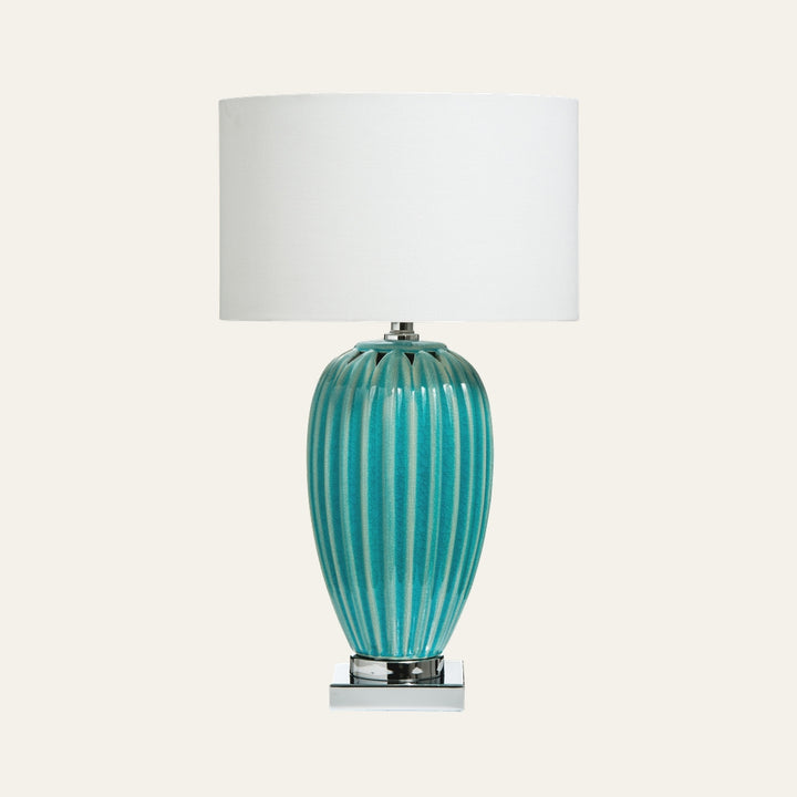 Avia Ceramic Table Lamp with turquoise ribbed glazed ceramic vase base, chrome square pedestal, and white drum fabric shade.