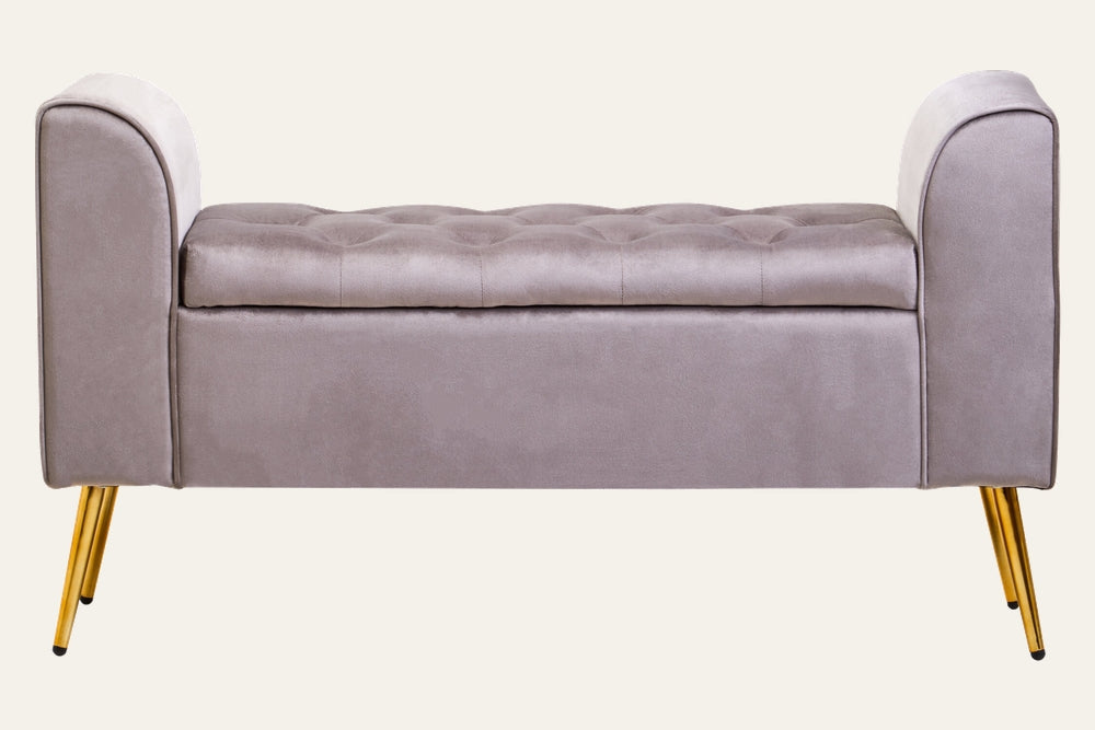 Caelis Mink Velvet Storage Bench with tufted top, mink velvet upholstery, curved armrests on both ends, and gold tapered metal legs