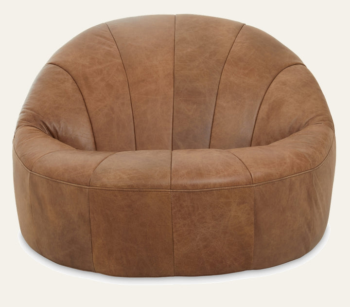 Caelver Chair — round low-profile lounge chair in distressed tan leather with curved channel-seamed back and cushioned seat