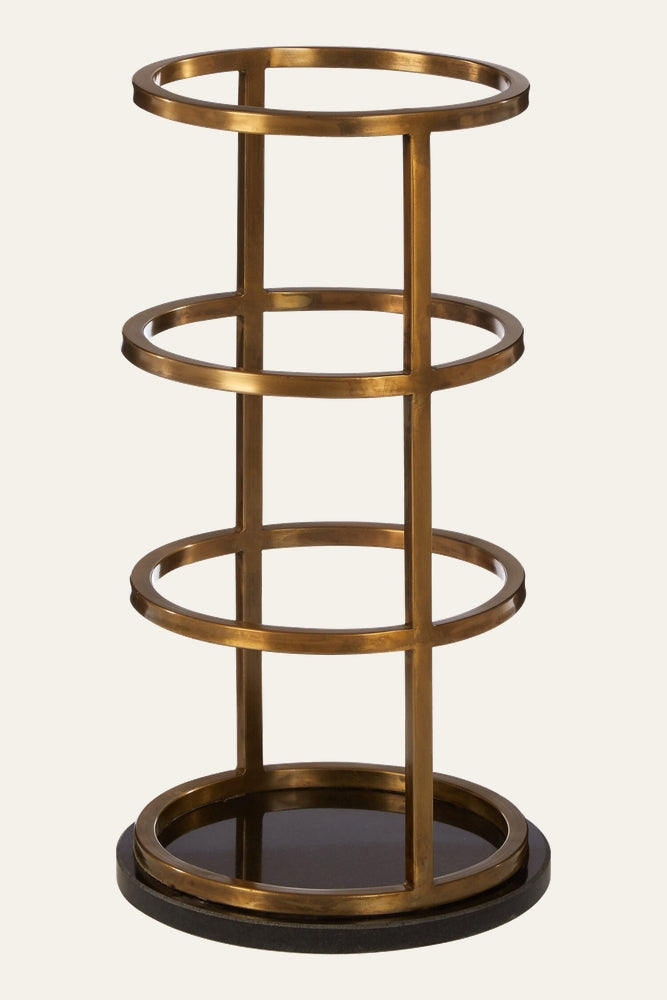 Caemora Marble Coat & Umbrella Stand — cylindrical open-frame stand with four brass-finish metal rings and vertical supports above a dark round marble base