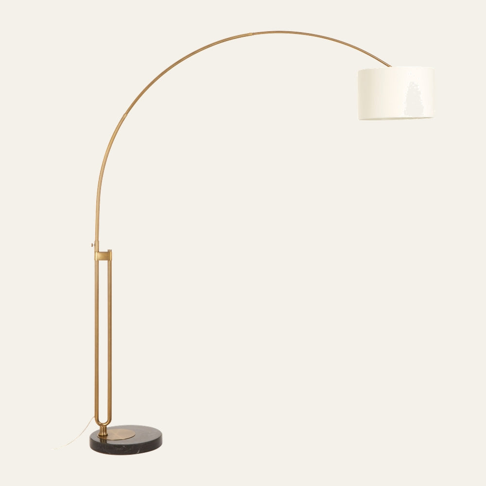 Caesira Brass Arc Floor Lamp with slim brass arched stem, white drum shade, and round dark marble base