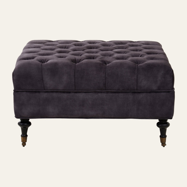 Caia Grey Velvet Ottoman, square tufted grey velvet ottoman with deep grid tufting and turned dark wood legs with brass casters