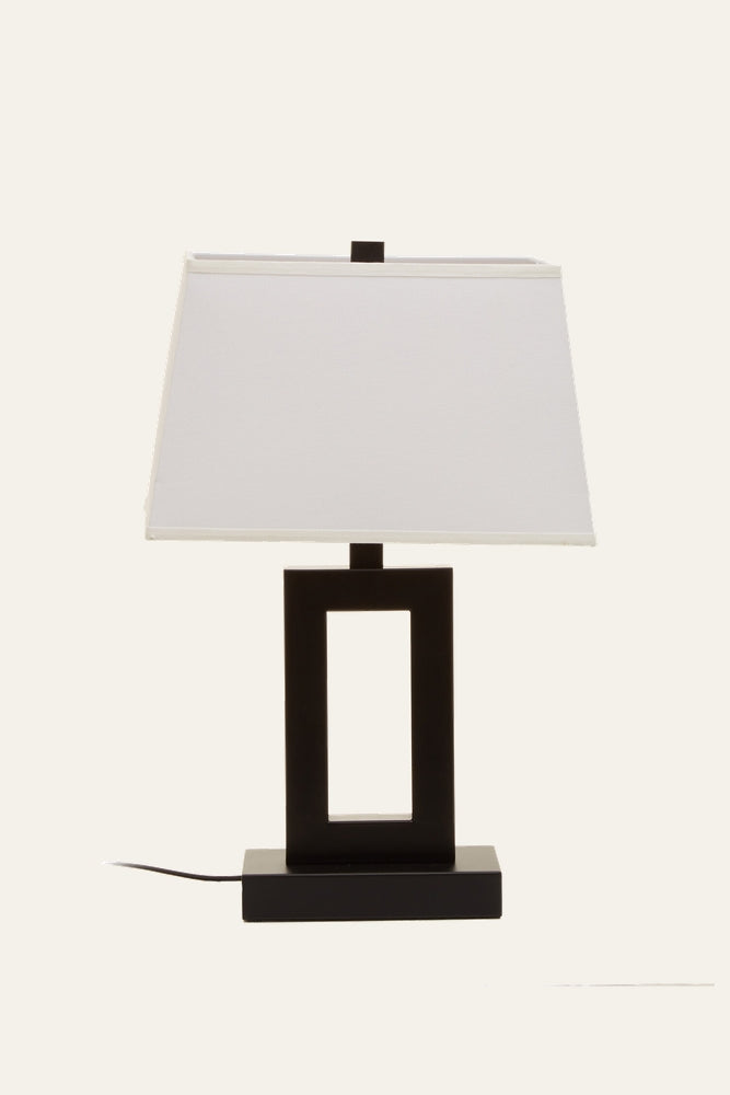 Celdora Fabric Table Lamp with white fabric tapered rectangular shade and black rectangular open-frame base on a black square platform