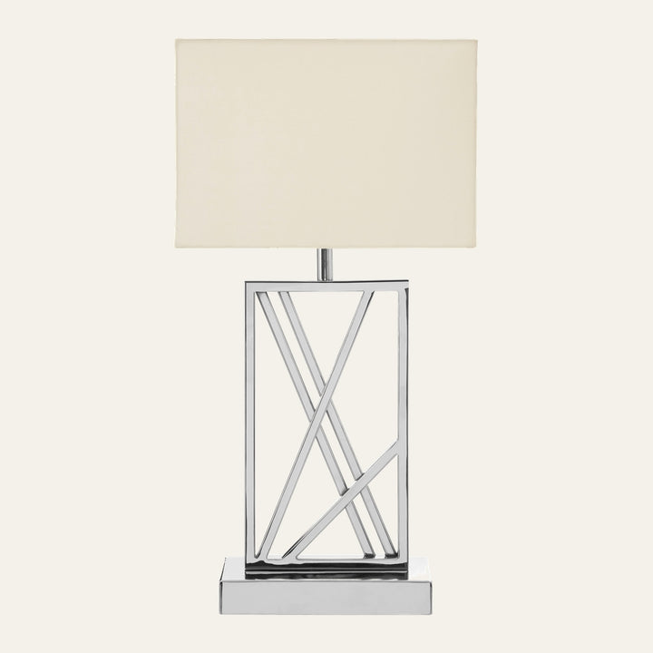 Celesse Metal Table Lamp with rectangular cream fabric shade and open geometric polished chrome metal base featuring diagonal crisscross bars on a rectangular chrome platform.