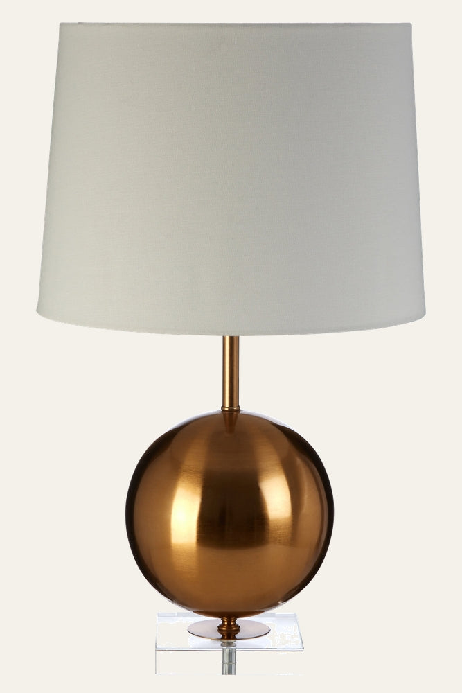 Celmira Gold Sphere Table Lamp with polished gold spherical metal base on a clear acrylic square plinth, slim gold stem and white fabric drum shade
