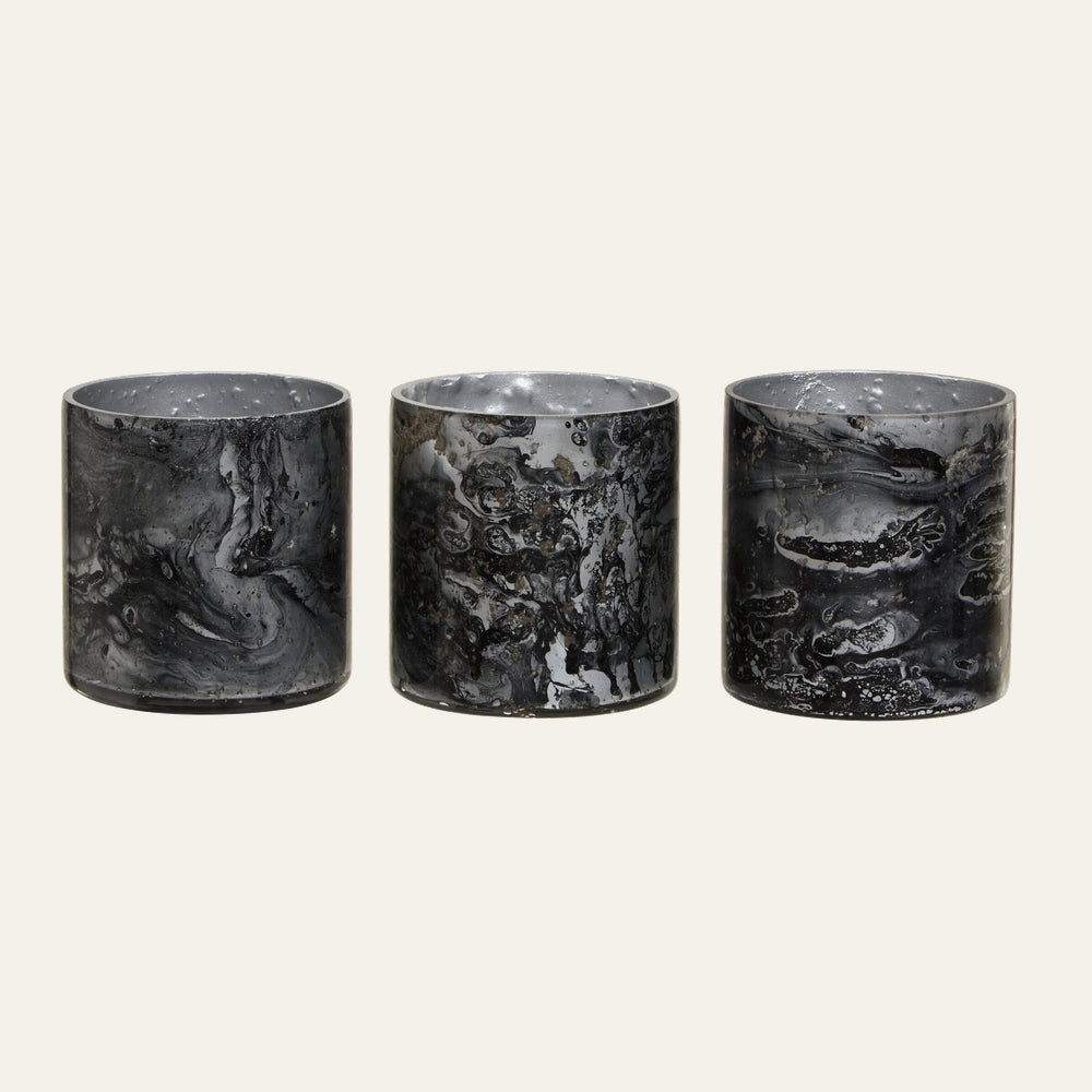 Celthea Marble Glass Tealight Holder Set: three cylindrical black-and-gray marbled glass tealight holders with glossy finish arranged side by side.