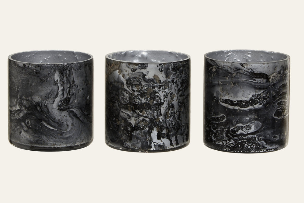 Celthea Marble Glass Tealight Holder Set — three short cylindrical marble glass tealight holders with black and gray swirling pattern and reflective silver-toned interiors