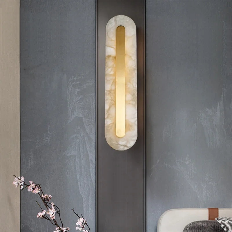 Decorative wall sconce with marble-like finish on a textured wall.