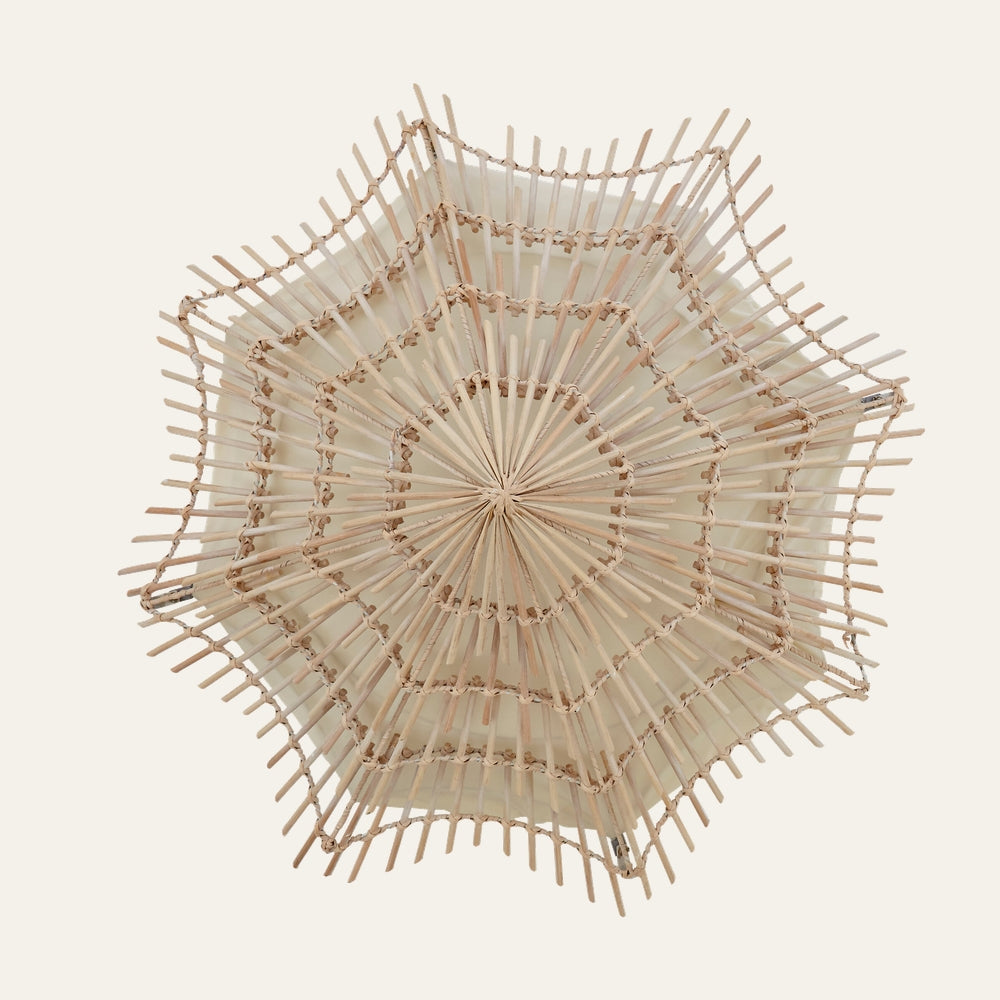 Corric Woven Rattan Wall Light, star-shaped layered rattan shade with radiating spokes and scalloped edges over a cream fabric diffuser in natural beige