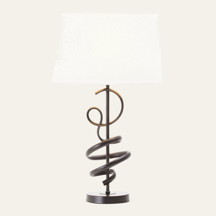 Dorrel Squiggle Table Lamp with white fabric drum shade and dark bronze squiggle metal base on round pedestal