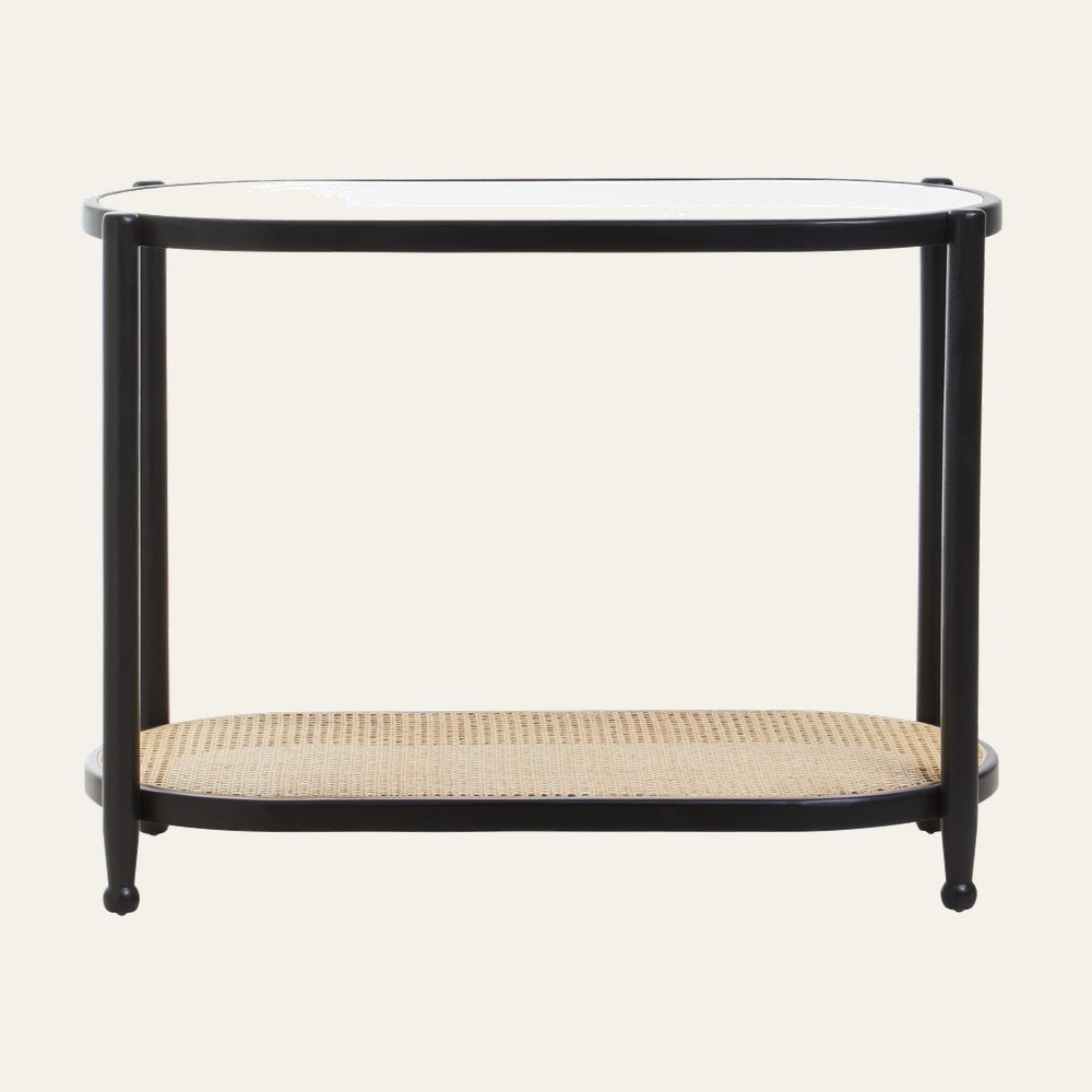 Drevan Rattan Glass Console Table with oval clear glass top, black slender frame and legs, and natural woven rattan lower shelf