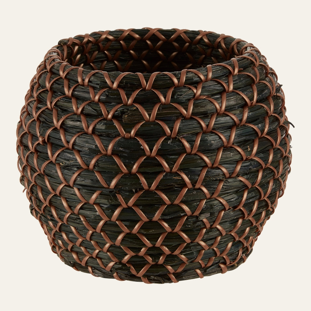 Elow Seagrass Basket Planter, round bulbous woven seagrass with dark green-black braided fibers and brown woven trim in a repeating diamond lattice pattern