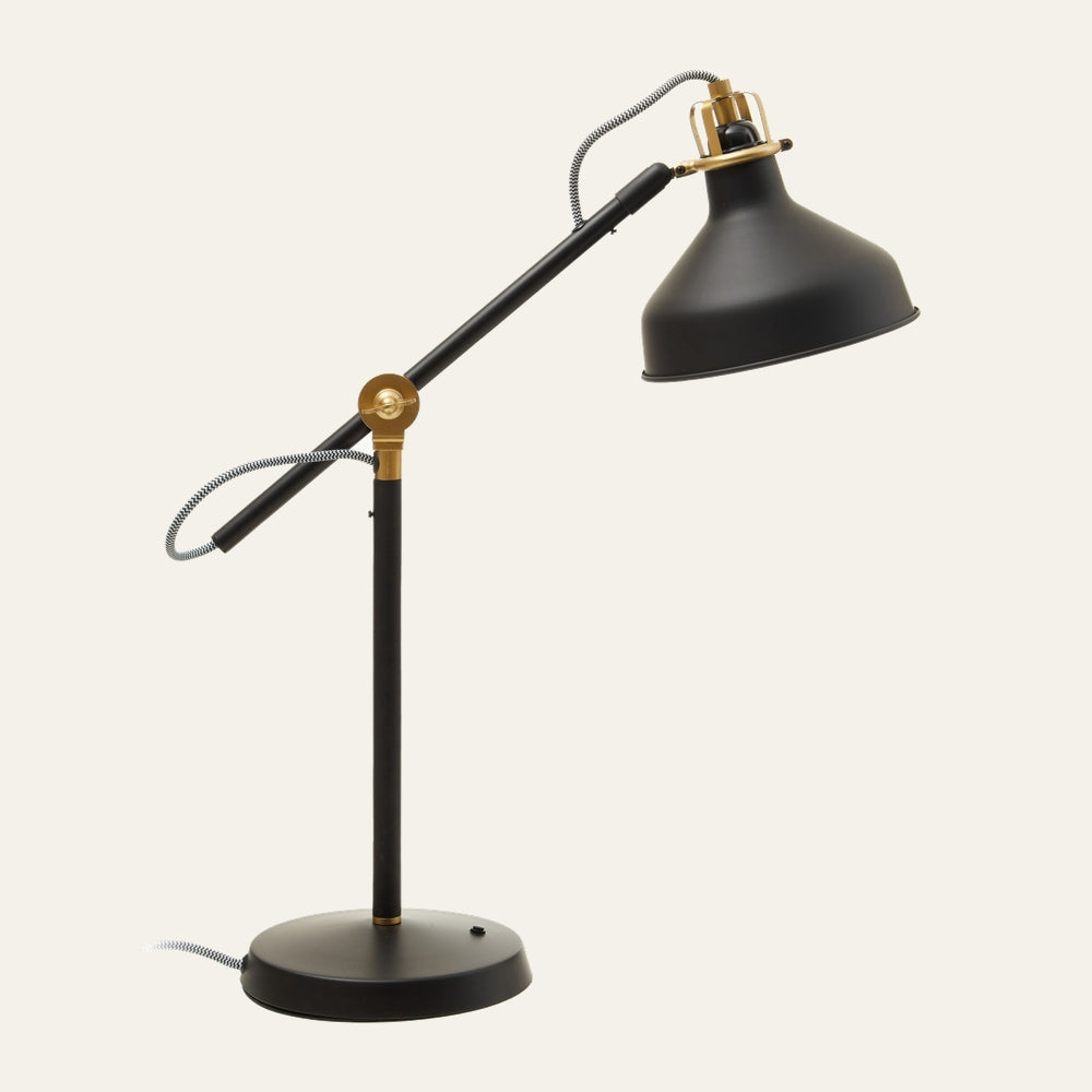 Elran Metal Desk Lamp — matte black metal adjustable arm and dome shade with brass-gold pivot accents, round base, and black-and-white braided cord