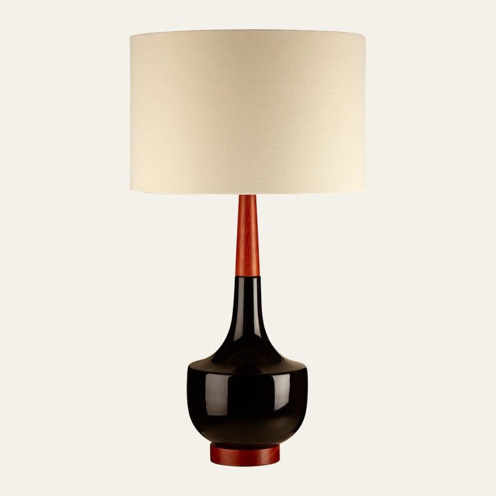 Elrielle Ceramic Base Table Lamp with cream fabric drum shade, glossy black ceramic rounded bottle base and warm reddish wood neck and foot