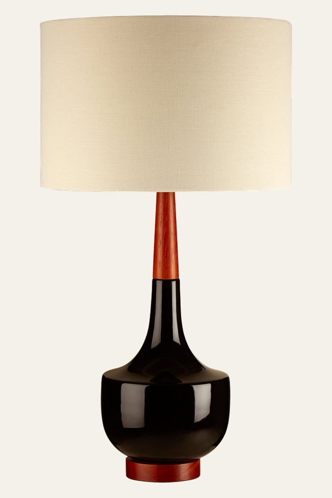 Elrielle Ceramic Base Table Lamp with glossy black rounded ceramic base, tapered reddish wood neck and foot, and beige fabric drum shade