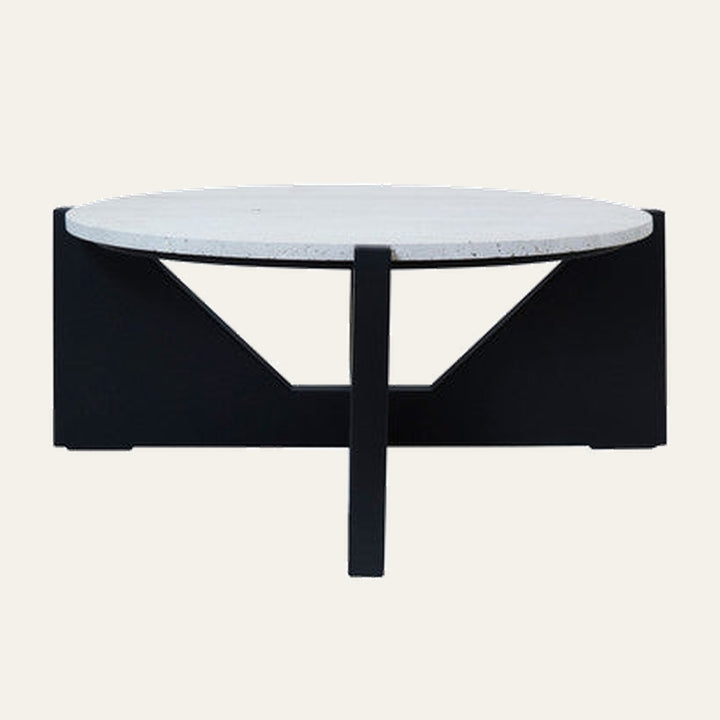 Elsen Travertine Coffee Table with round light travertine top and low black geometric base featuring triangular cutouts and central support
