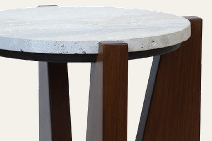 Elsen Travertine Side Table with round light travertine top, black metal rim, and angled dark wood legs