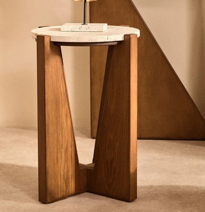 Elsen Travertine Side Table with round off-white travertine top on a sculptural V-shaped warm brown wooden base with triangular cutout