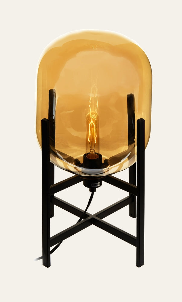 Erathia Glass Table Lamp with amber glass dome shade, exposed filament bulb and black metal X-frame base