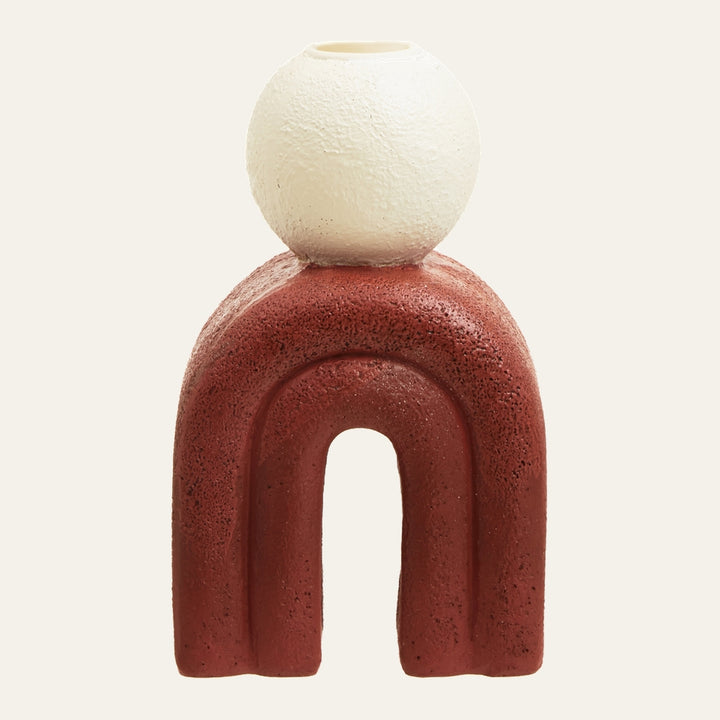 Eriya Candle Holder with textured matte rust-red arch base topped by a textured off-white spherical candle cup