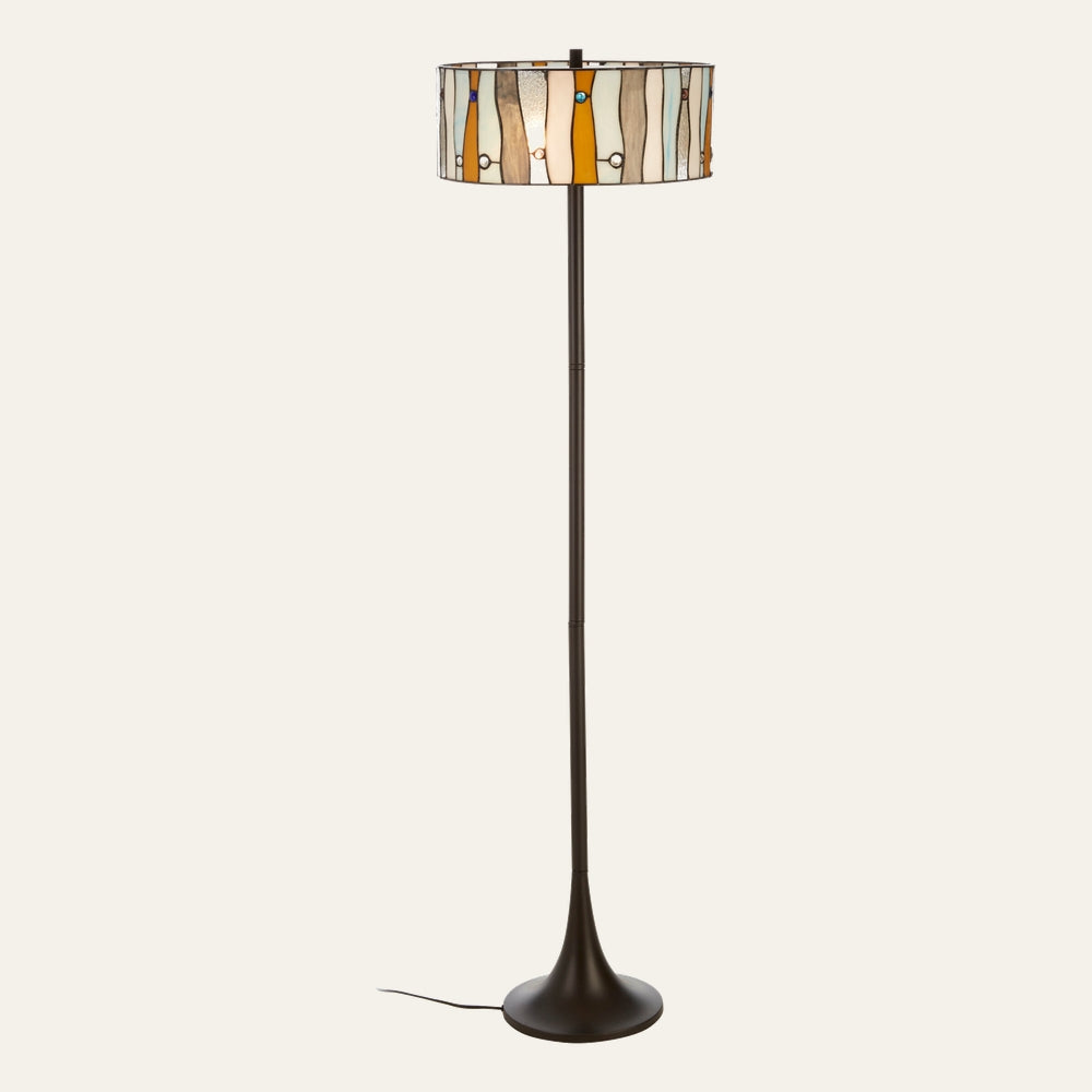 Evaya Floor Lamp with a multicolored stained-glass drum shade of vertical panels and round glass accents, slim dark metal pole and flared round base with visible cord
