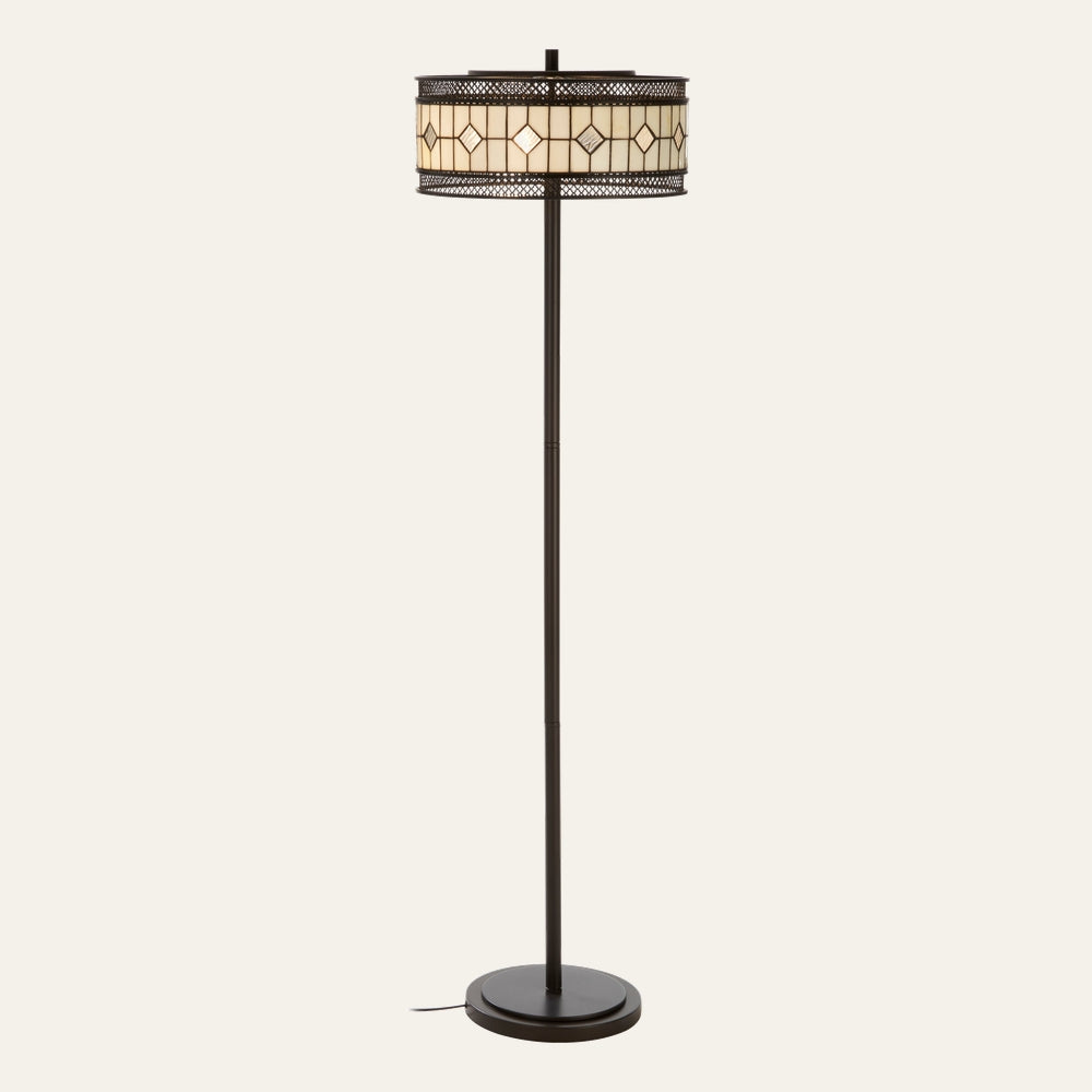 Evaya Floor Lamp with slim dark bronze metal pole and round base, drum stained-glass shade in cream diamond pattern with decorative metal lattice trim